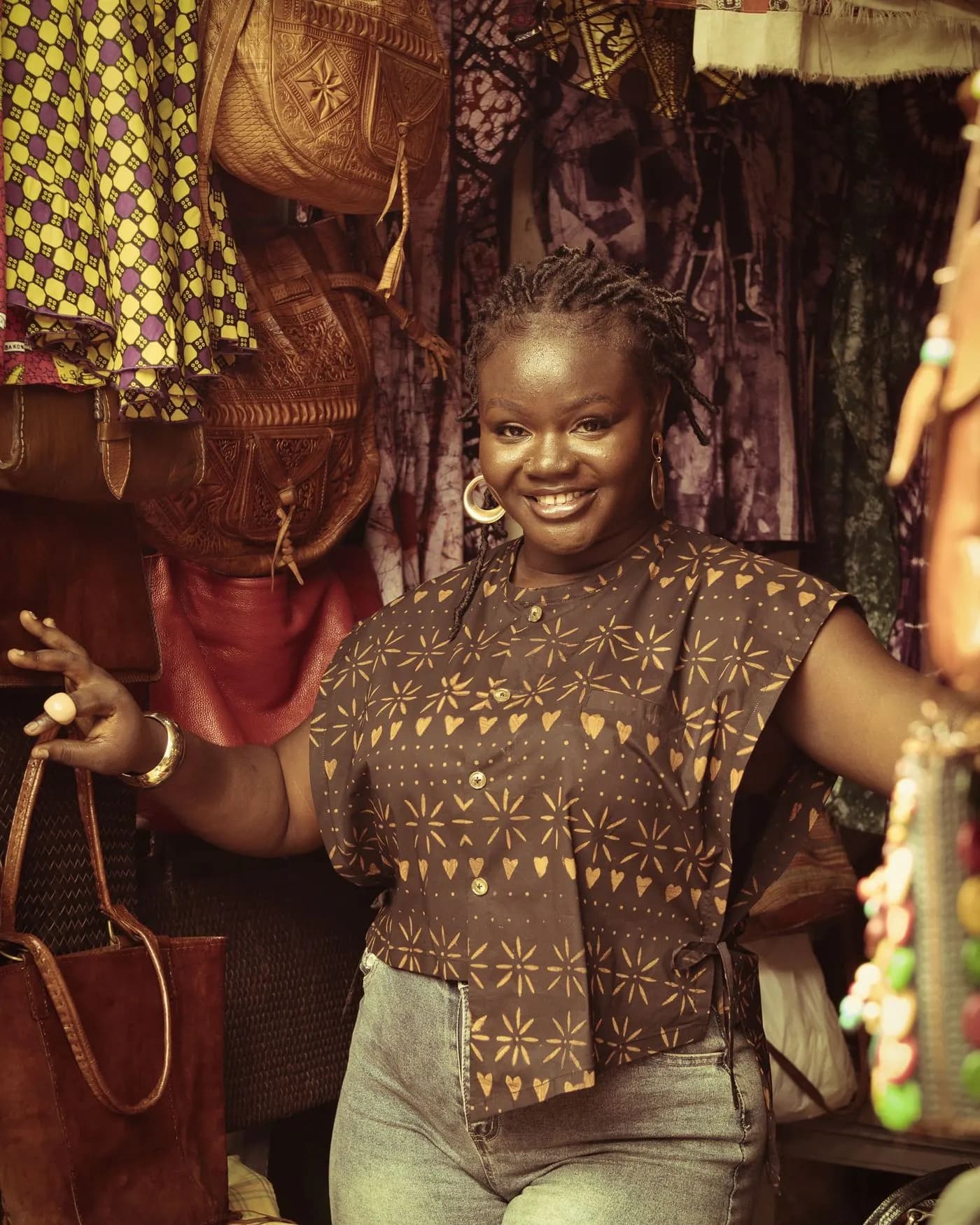 Commerçante souriante dans son étal de tissus et d’accessoires
