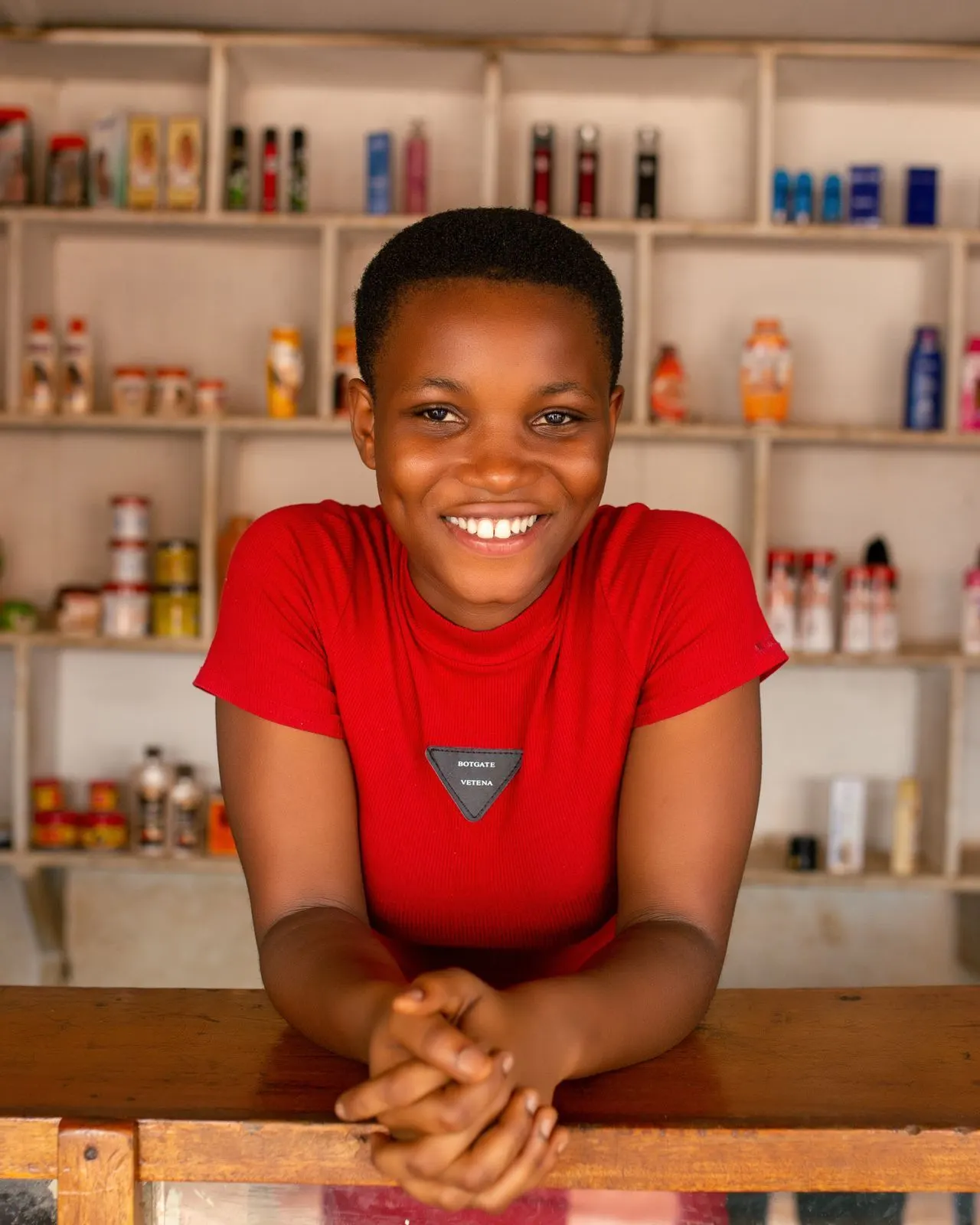 Jeune commerçante souriante derrière le comptoir de sa boutique